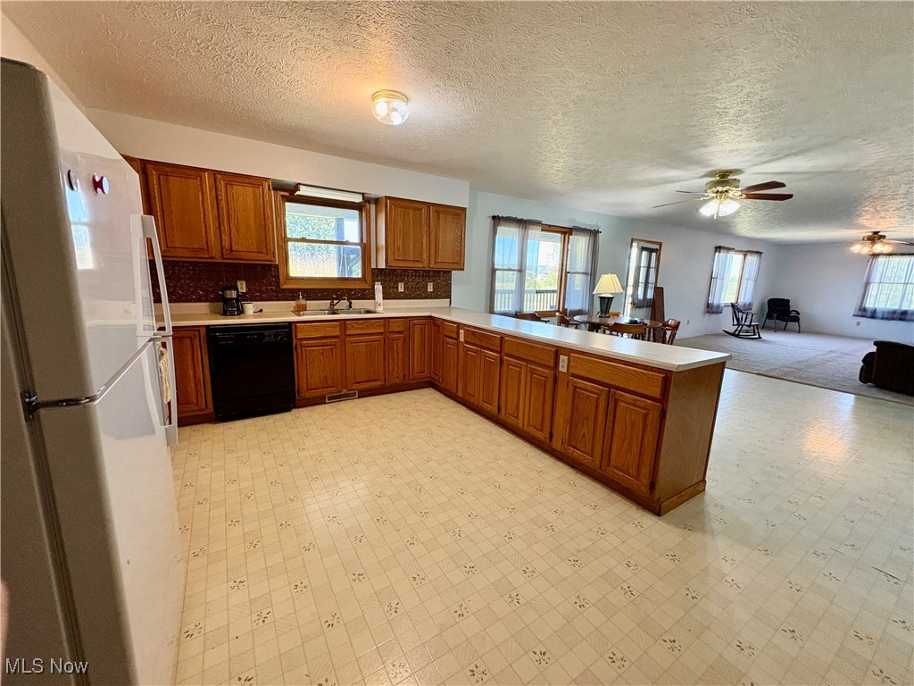 3333 Force Road Shreve, OH 44676 - Photo 26 of 26 Kitchen with a peninsula, freestanding refrigerator, brown cabinets, light countertops, and open floor plan