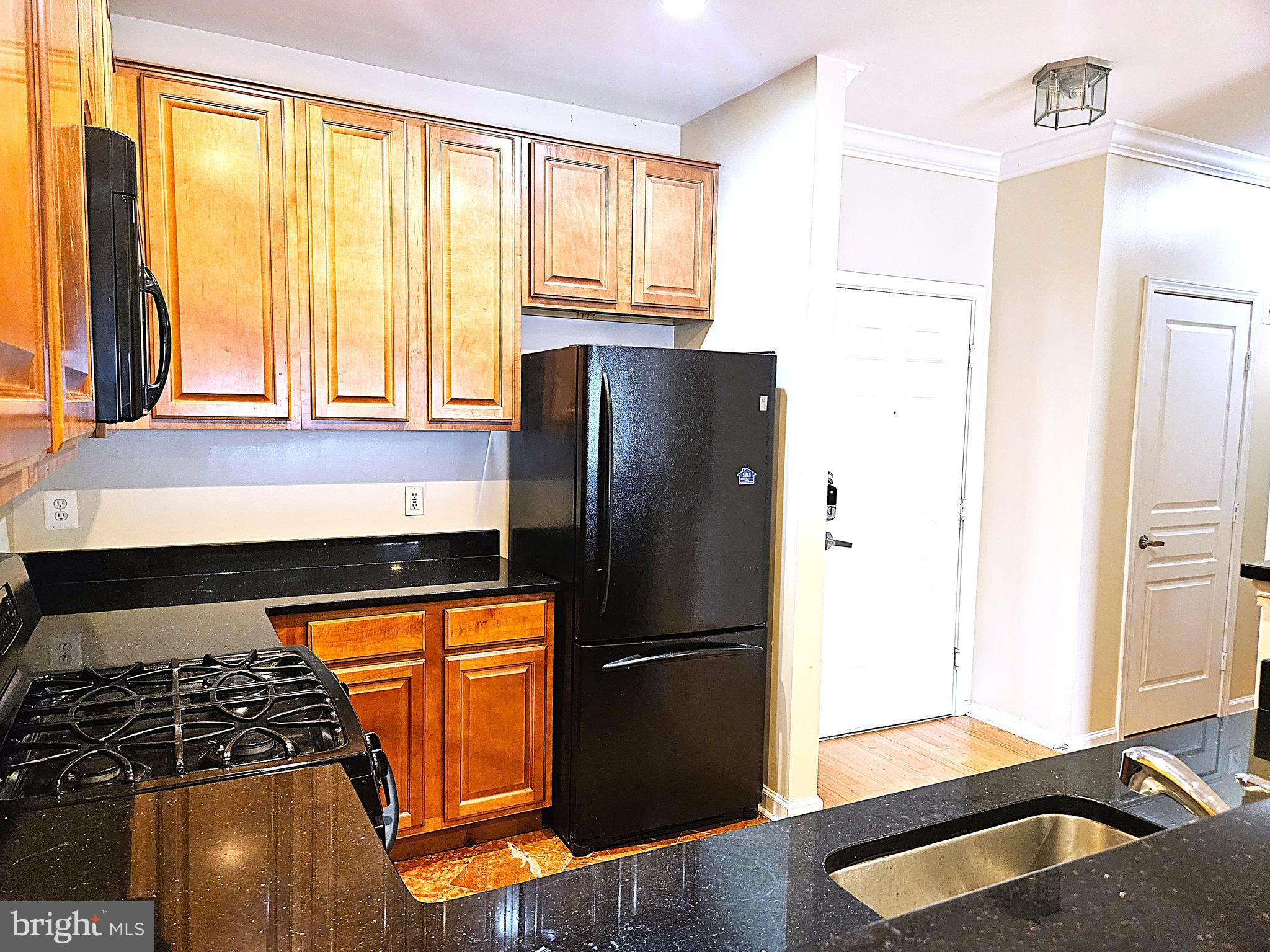 12000 Market Street, Unit 283 Reston, VA 20190 - Photo 5 of 36 a kitchen with granite countertop a refrigerator and a sink