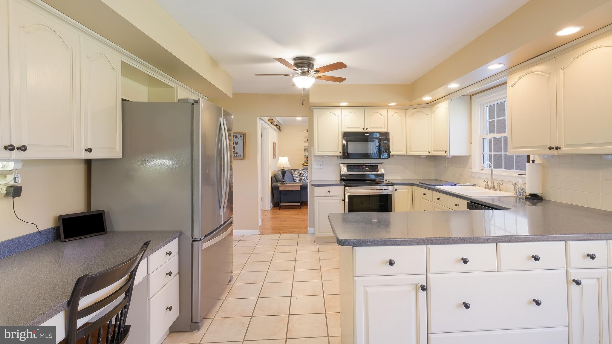 12 Pine Valley Road Doylestown, PA 18901 - Photo 11 of 63 a kitchen with stainless steel appliances kitchen island granite countertop a refrigerator a sink dishwasher a stove with white cabinets