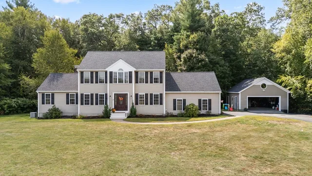 a front view of a house with a yard and trees