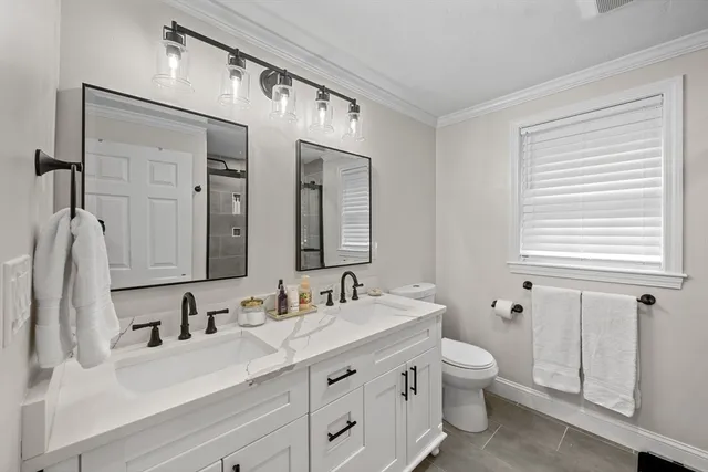 a bathroom with a double vanity sink mirror and toilet