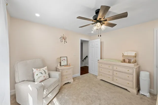 a living room with furniture and a ceiling fan