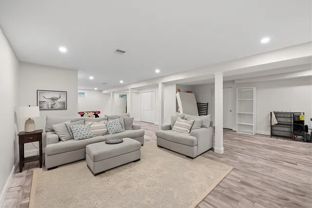 a living room with furniture and a wooden floor