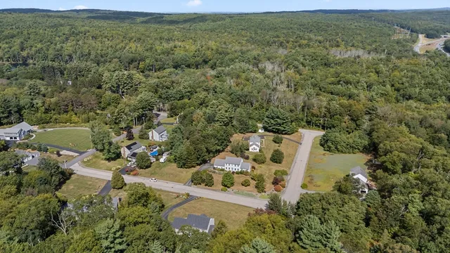 an aerial view of residential house with outdoor space and trees all around