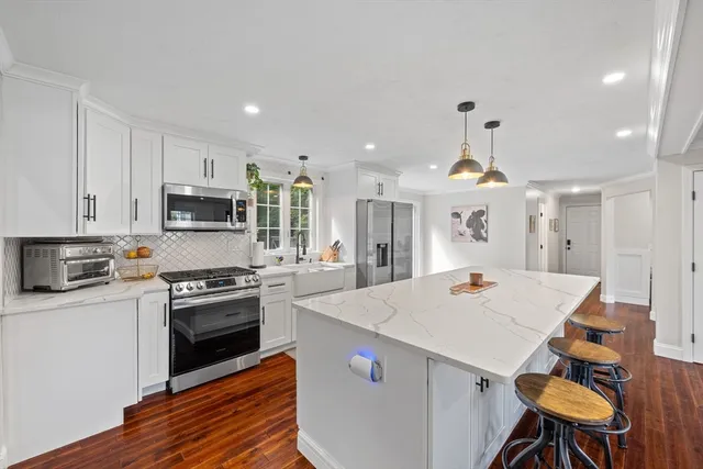 a large kitchen with kitchen island a stove a sink a stove and a refrigerator