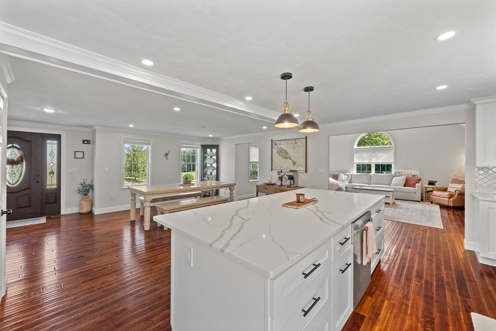 8 Virginia Avenue Sutton, MA 01590 - Photo 10 of 42 a view of a kitchen with kitchen island a stove a sink a refrigerator and a dining table with wooden floor