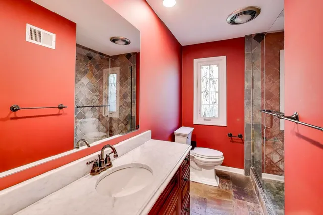 a bathroom with a sink a toilet and shower