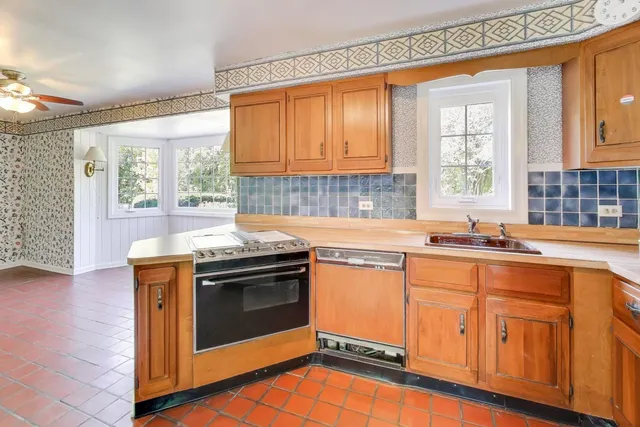a kitchen with stainless steel appliances granite countertop a sink a stove and a wooden floors