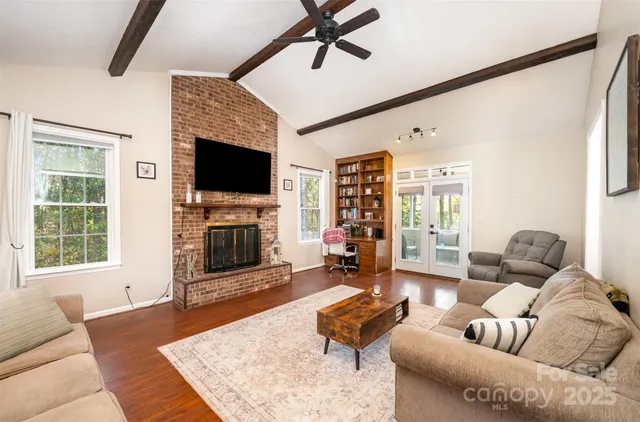 a living room with furniture a flat screen tv and a fireplace