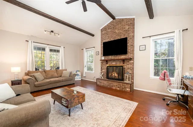 a living room with furniture a flat screen tv and a fireplace