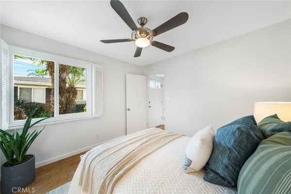a bedroom with a large bed chandelier and a window