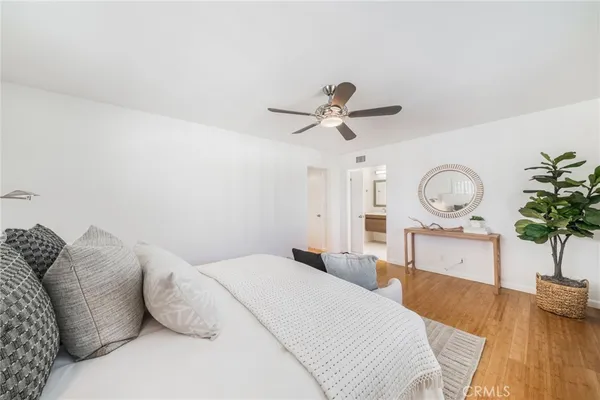 a bedroom with a bed mirror and a large window