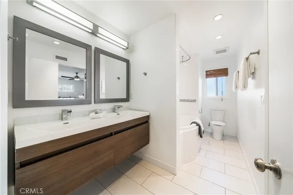 a bathroom with a double vanity sink mirror and toilet