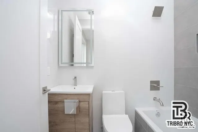 a bathroom with a toilet sink and mirror