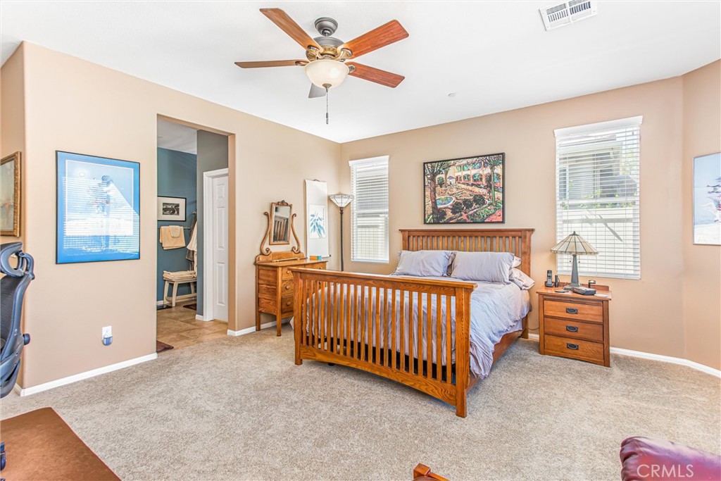1476 Signal Peak Beaumont, CA 92223 - Photo 21 of 50 a spacious bedroom with a bed and a chandelier