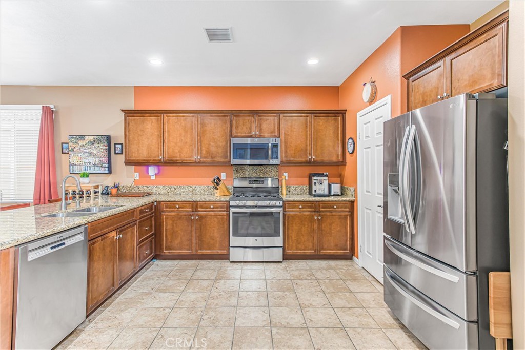 1476 Signal Peak Beaumont, CA 92223 - Photo 7 of 50 a kitchen with stainless steel appliances granite countertop a refrigerator and a sink