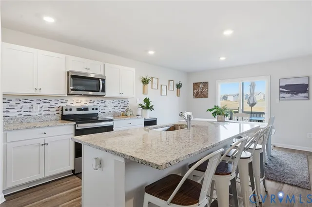 a kitchen with granite countertop stainless steel appliances sink microwave and cabinets