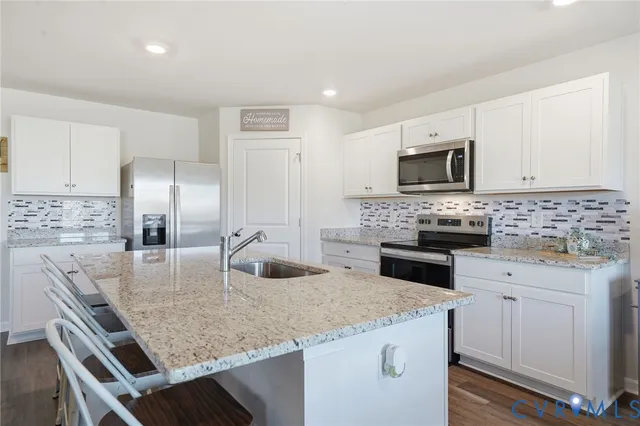 a kitchen with kitchen island a counter top space appliances and cabinets