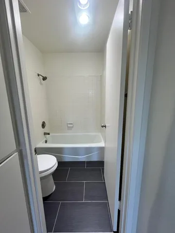 a bathroom with a sink a toilet a mirror and shower