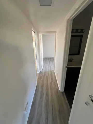 a view of a hallway with wooden floor and staircase