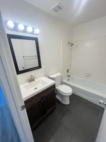 a bathroom with a toilet sink a mirror and a shower