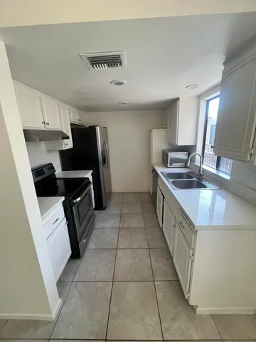 a kitchen with a sink a stove top oven and refrigerator