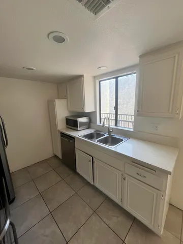 a kitchen with a sink cabinets and window
