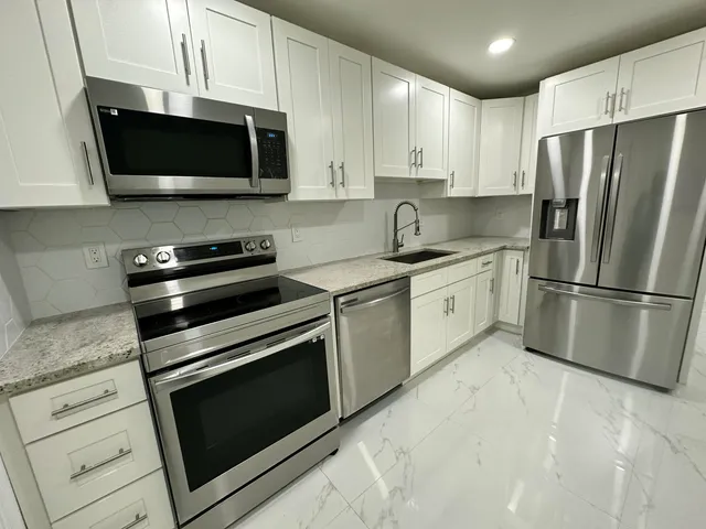 a kitchen with stainless steel appliances granite countertop a stove microwave and refrigerator