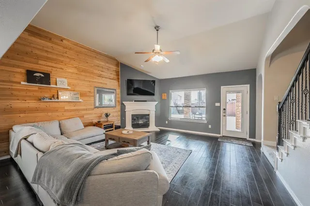 a living room with furniture a fireplace and a flat screen tv