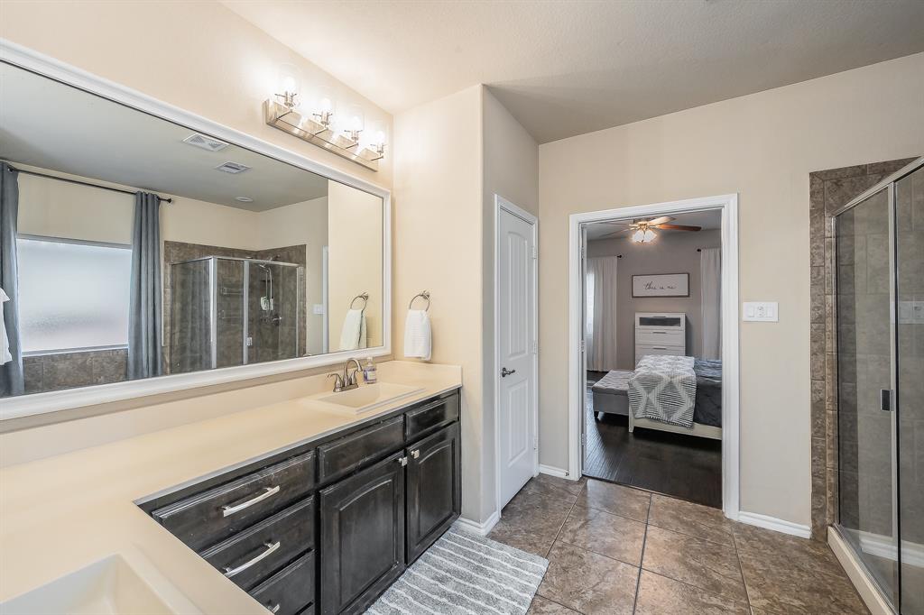 10417 Boxthorn Court Fort Worth, TX 76177 - Photo 23 of 40 a spacious bathroom with a sink a large mirror and a shower