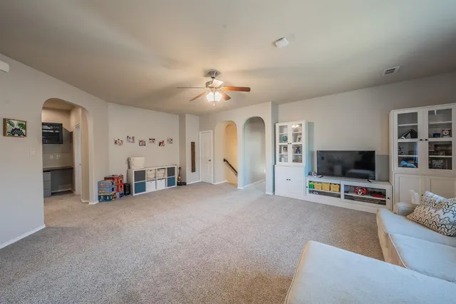 a view of a livingroom with furniture and a ceiling fan