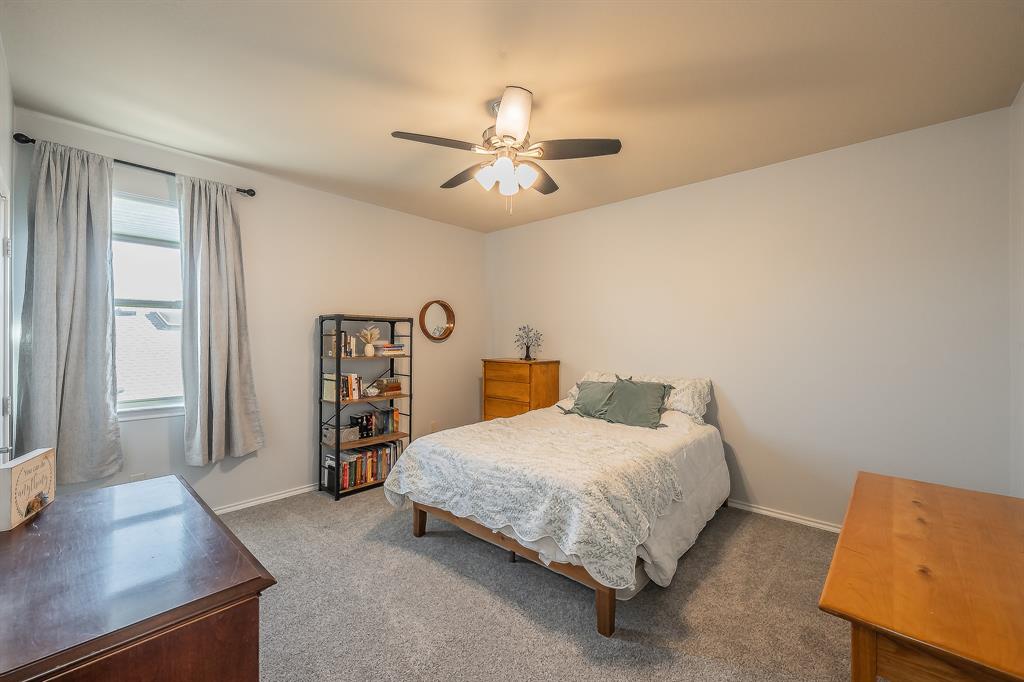 10417 Boxthorn Court Fort Worth, TX 76177 - Photo 33 of 40 a bedroom with a bed and a chandelier