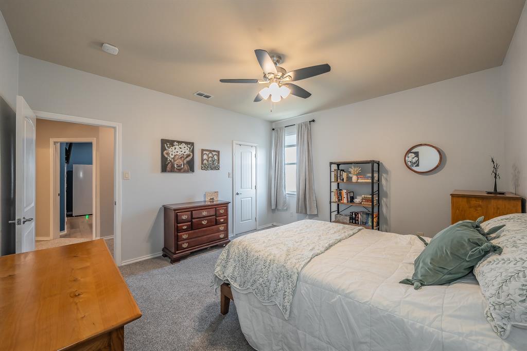 10417 Boxthorn Court Fort Worth, TX 76177 - Photo 34 of 40 a bedroom with a bed and a chandelier