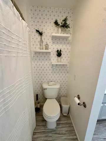 a bathroom with a toilet and a shower