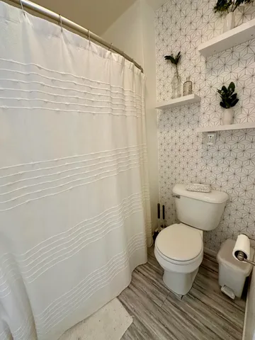 a bathroom with a toilet and a shower