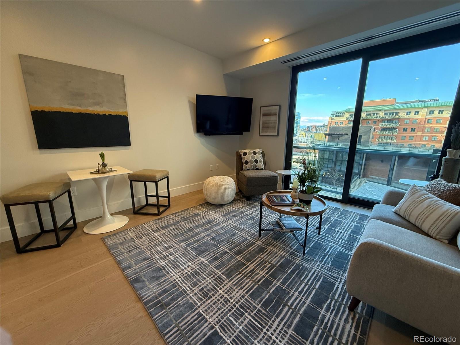 1901 Wazee Street, Unit 412 Denver, CO 80202 - Photo 2 of 33 a living room with furniture wooden floor and a floor to ceiling window