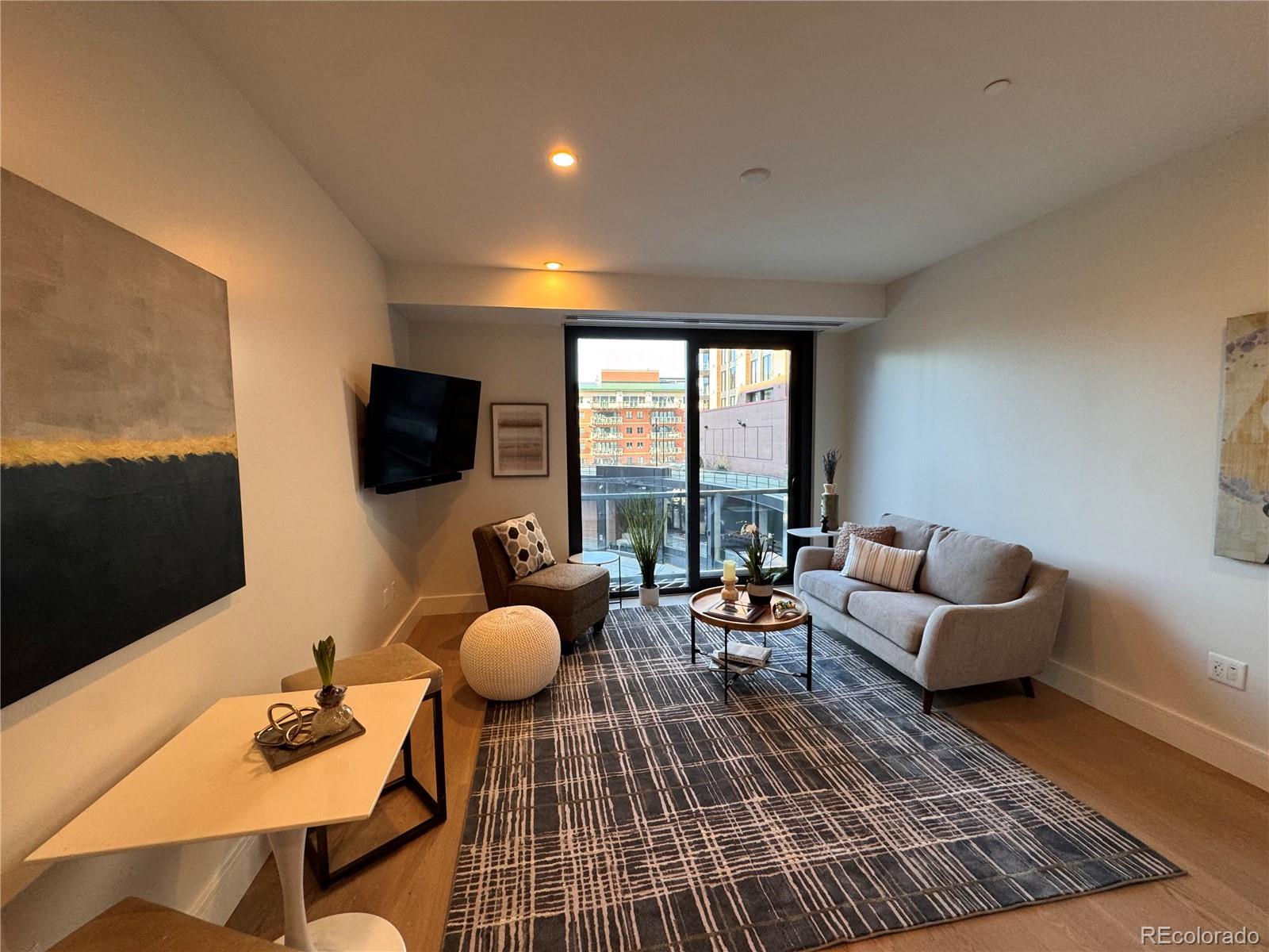 1901 Wazee Street, Unit 412 Denver, CO 80202 - Photo 23 of 33 a living room with furniture and a flat screen tv