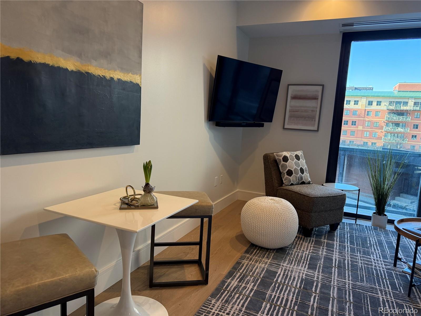 1901 Wazee Street, Unit 412 Denver, CO 80202 - Photo 5 of 33 a living room with furniture a flat screen tv and kitchen view