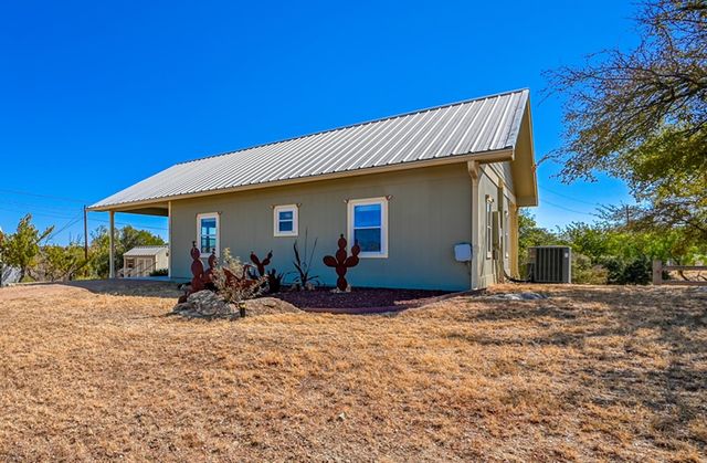 a view of a house with backyard and sitting area