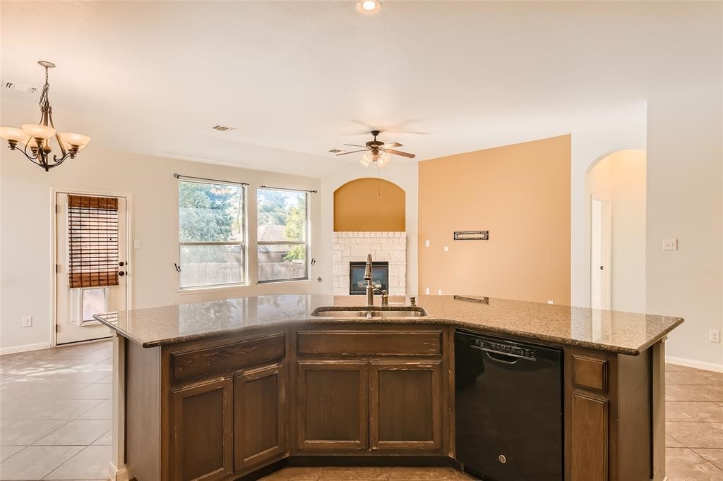290 Maeves Way Austin, TX 78737 - Photo 6 of 13 An inviting open-concept kitchen boasts a functional island and overlooks a cozy living area with a fireplace.