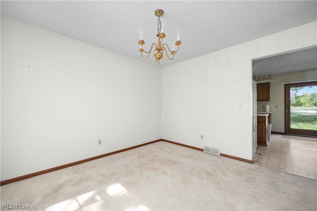 722 Jaycox Road Avon Lake, OH 44012 - Photo 16 of 48 Carpeted interior space featuring a brass-tone chandelier and white walls with wood-finish trim