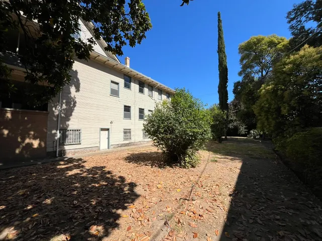 a view of a white house with a yard