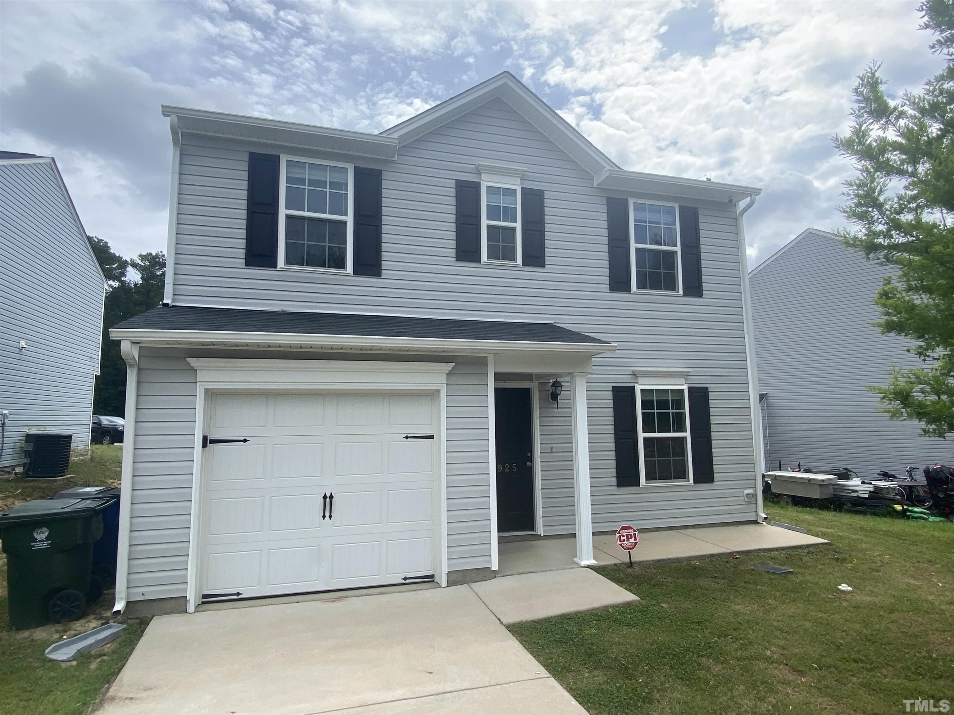 a front view of a house with a garden and yard