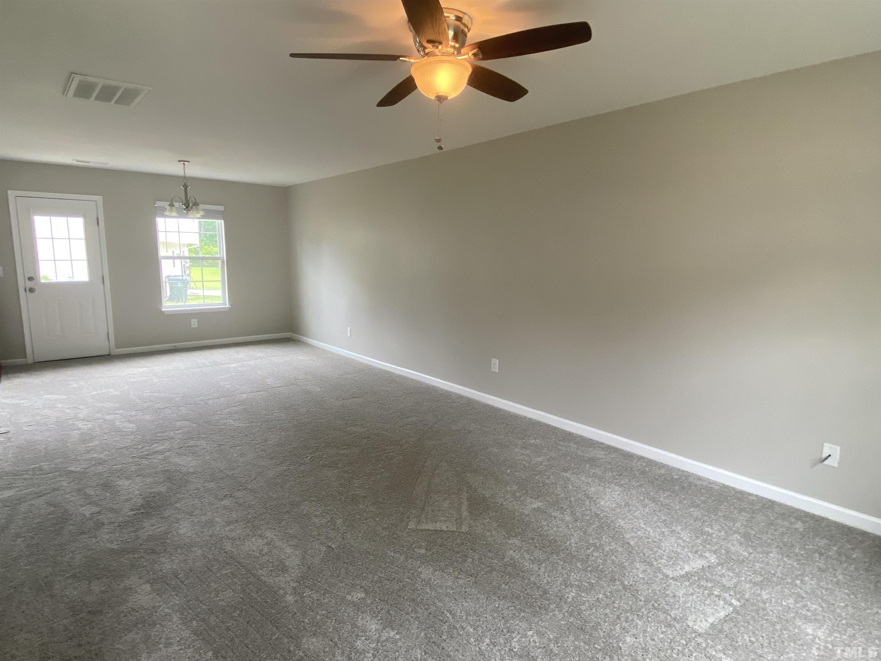 2925 Filbert Street Raleigh, NC 27610 - Photo 2 of 3 an empty room with windows and a ceiling fan