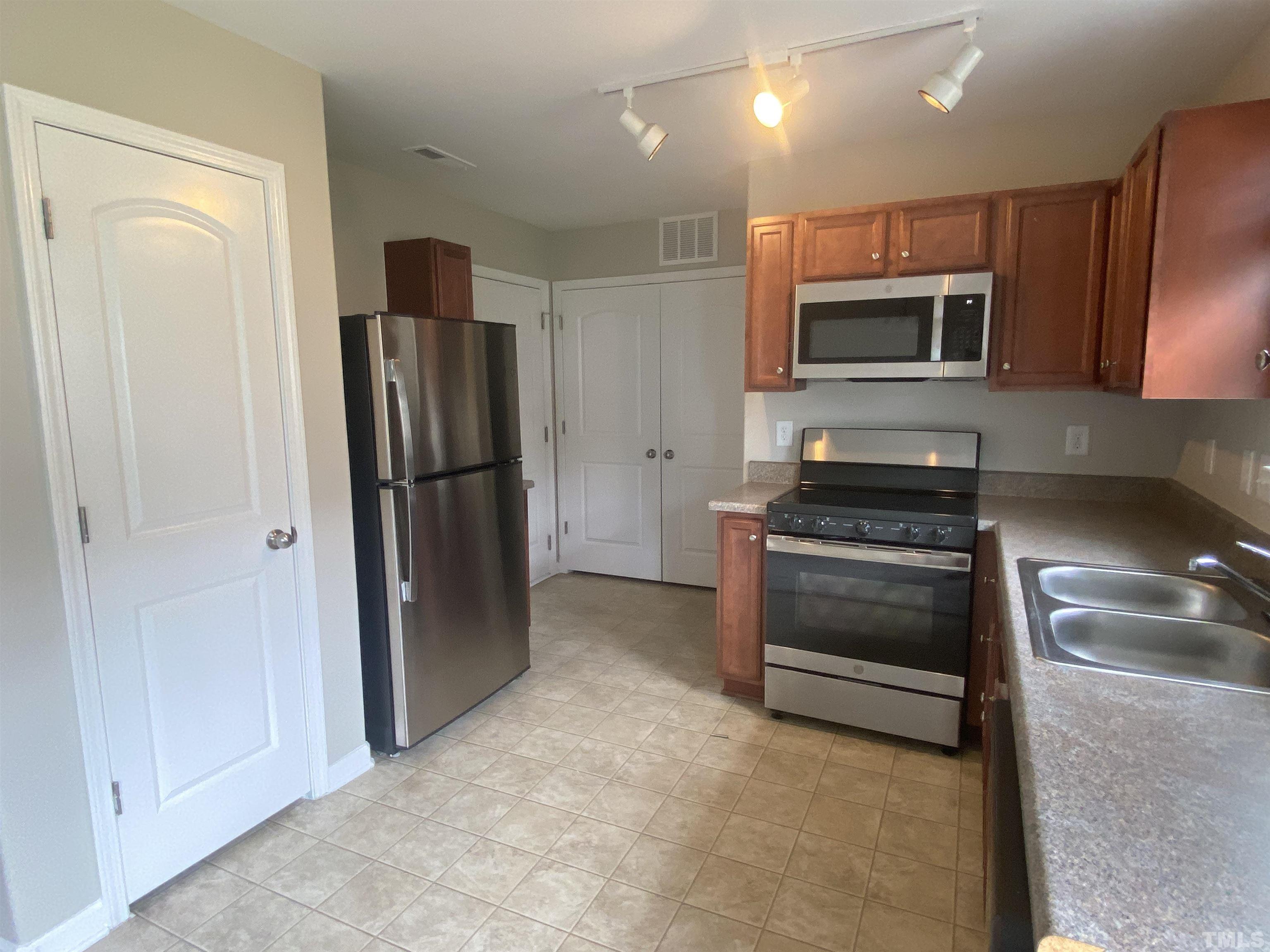 2925 Filbert Street Raleigh, NC 27610 - Photo 3 of 3 a kitchen with stainless steel appliances granite countertop a refrigerator and a stove