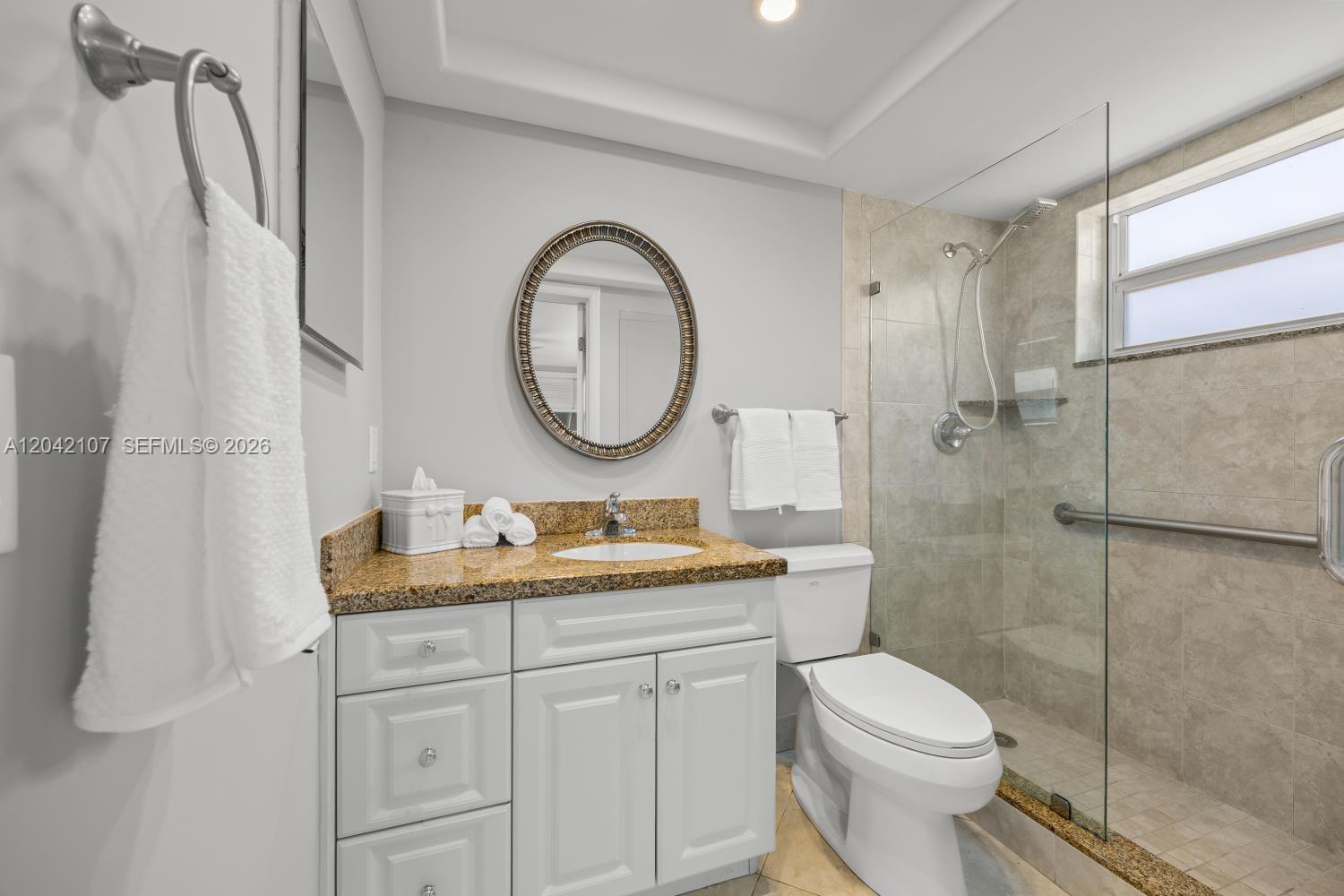 3213 Colony Club Road, Unit 3E Pompano Beach, FL 33062 - Photo 24 of 31 a bathroom with a toilet a sink and a mirror