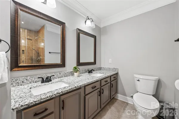 a bathroom with a granite countertop toilet sink and mirror