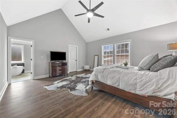 a spacious bedroom with a bed and a flat screen tv