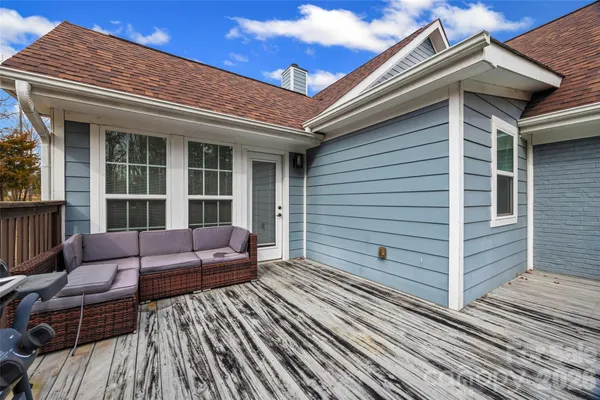 a view of a patio with couches chairs and wooden floor