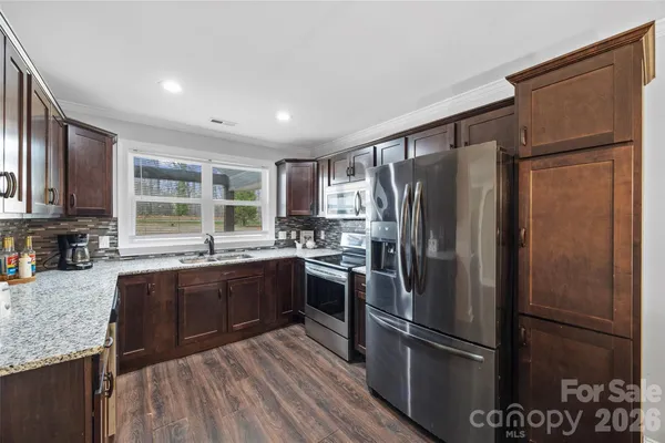 a kitchen with stainless steel appliances granite countertop a refrigerator and a sink